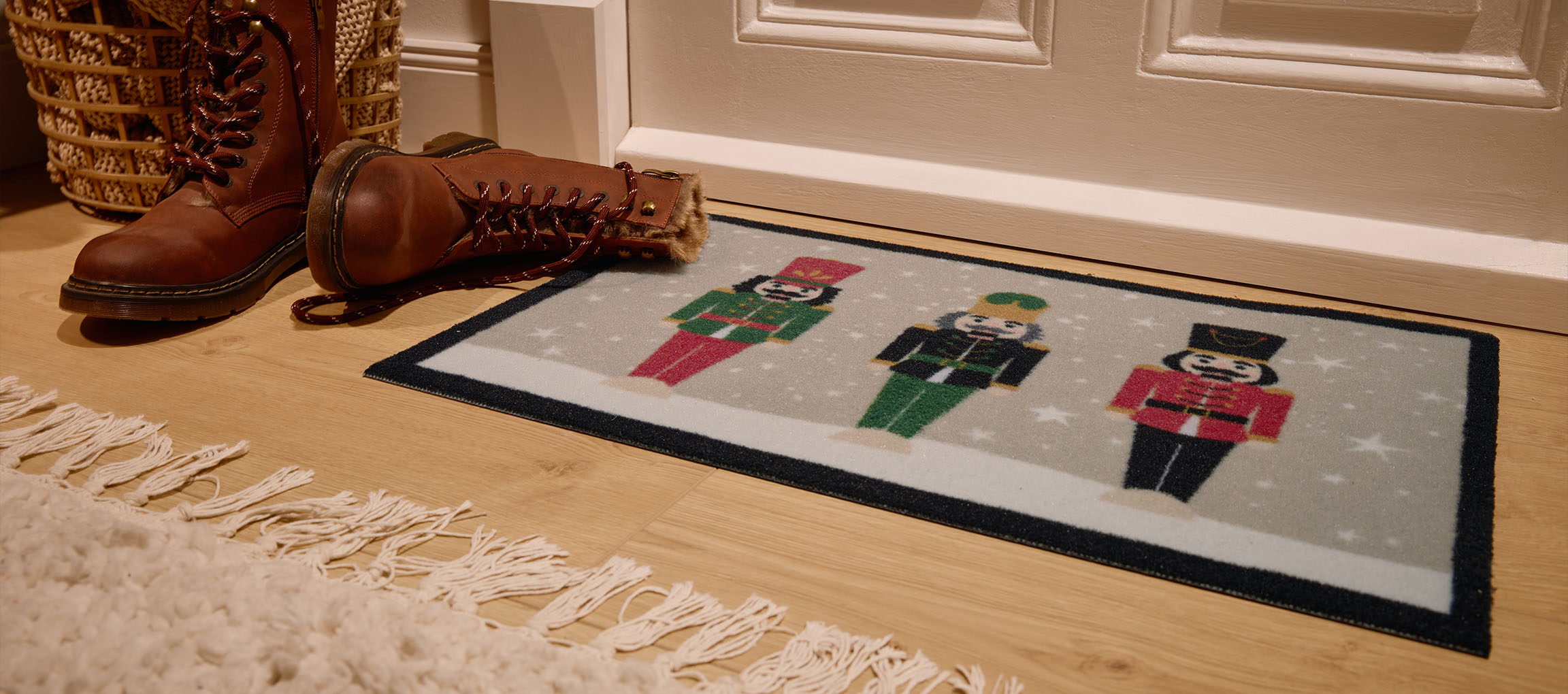 Christmas nutcracker doormat, brown boots, and wicker basket at the entrance.