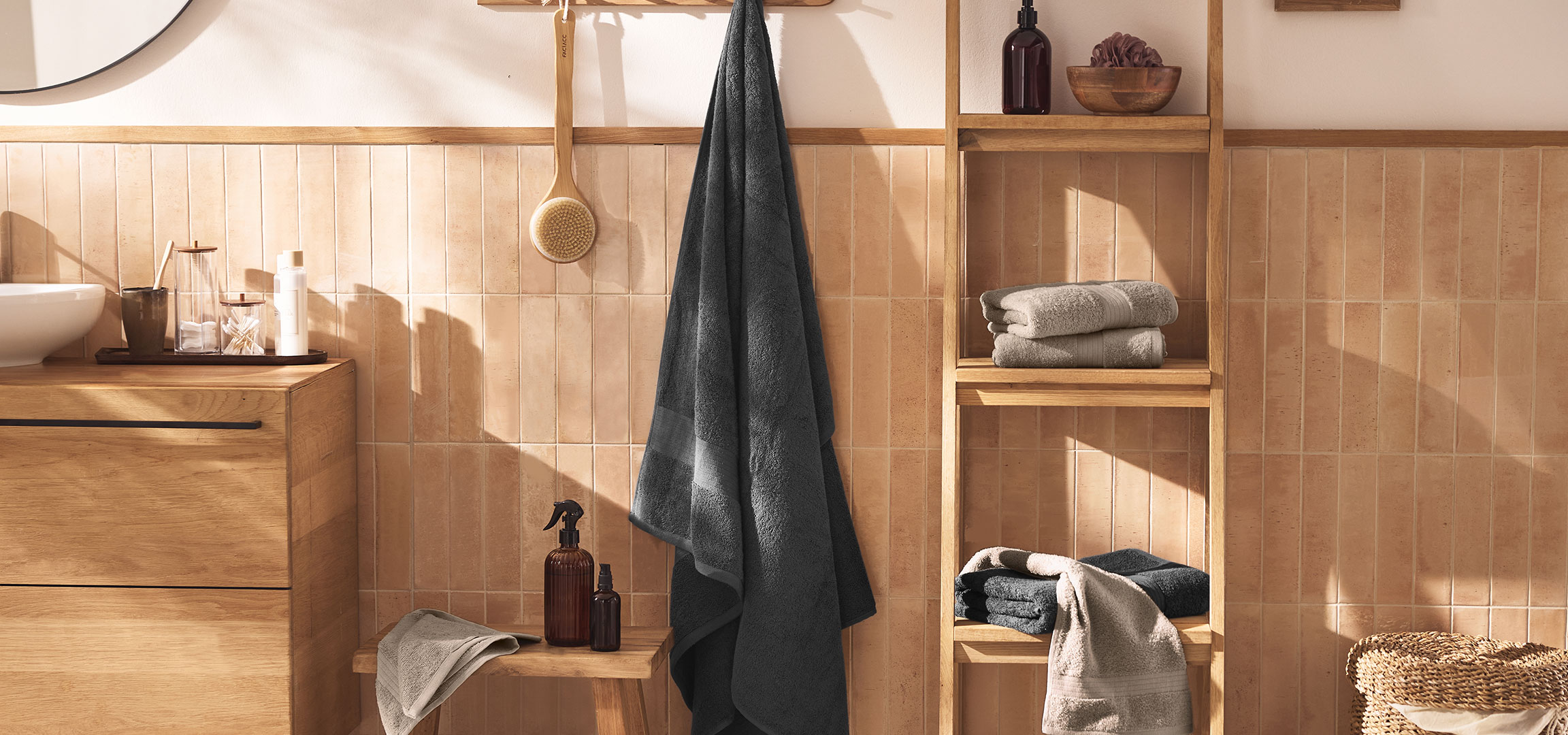 aiLabeling.aiLabelForImageAltText: Modern bathroom with a sink, wooden vanity, towels, and accessories.