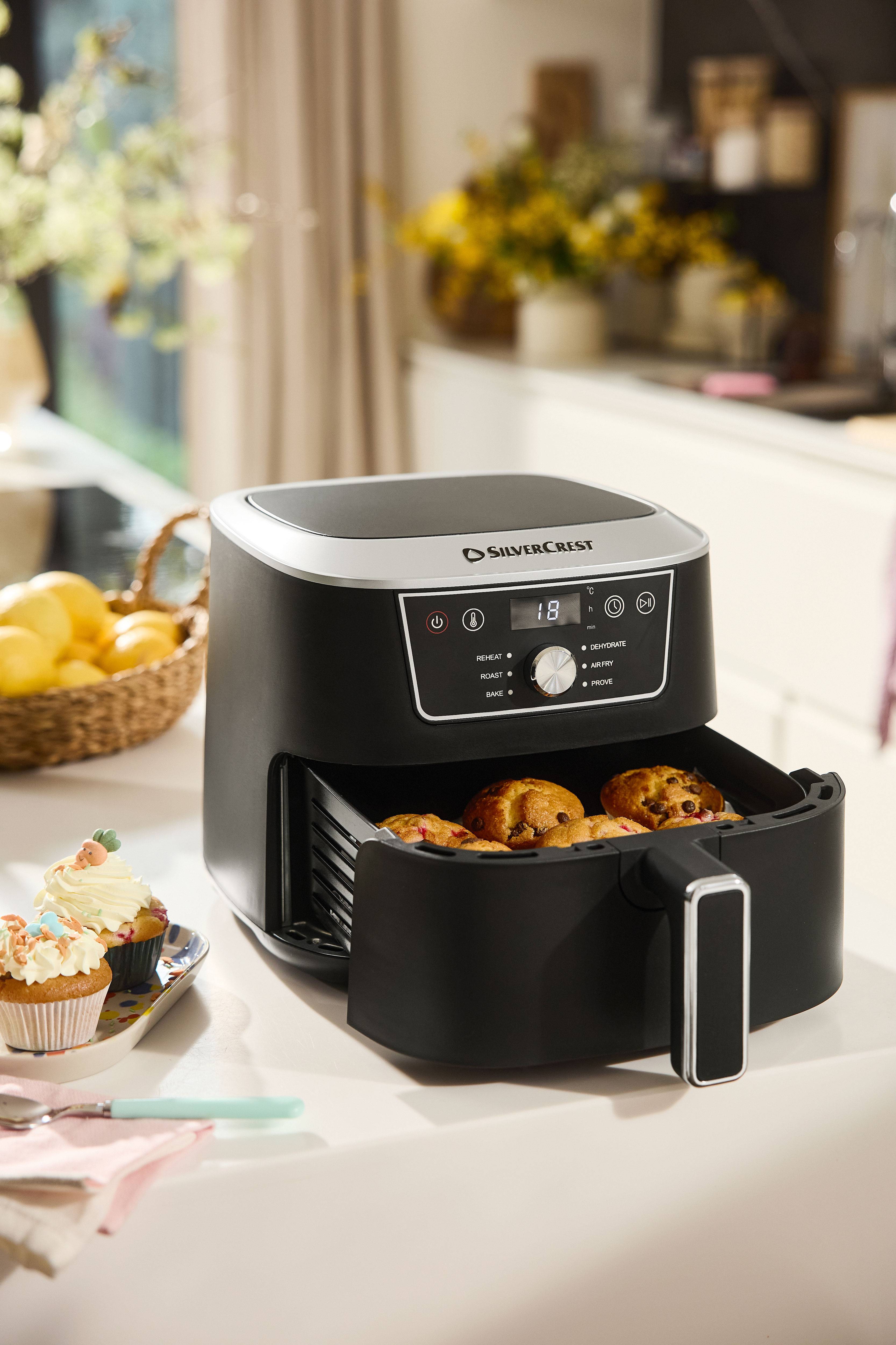 Black Silvercrest air fryer with an open drawer full of muffins on a kitchen counter.