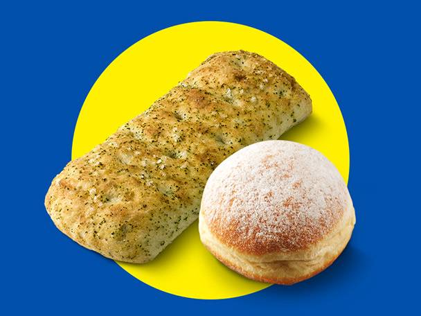 Focaccia bread and a powdered sugar donut on a yellow circle against a blue background.