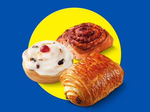 A cinnamon roll, a pastry with icing and a cherry, and a pain au chocolat on a yellow circle.